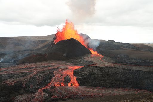 A volcanic eruption with glowing orange lava flow surrounded by a pool of bubbling magma