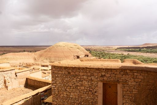 An old house in Ouarzazate city Morocco with the horizon and hills in the background under the gray sky