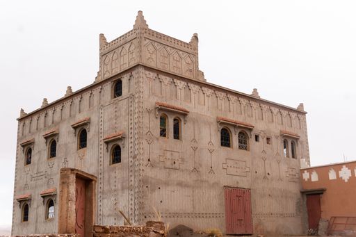 A beautiful old building with ornamented walls in Morocco against the bright white sky