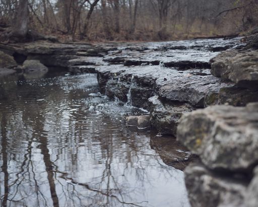 A selective focus closeup of the flowing water from the river to a stream
