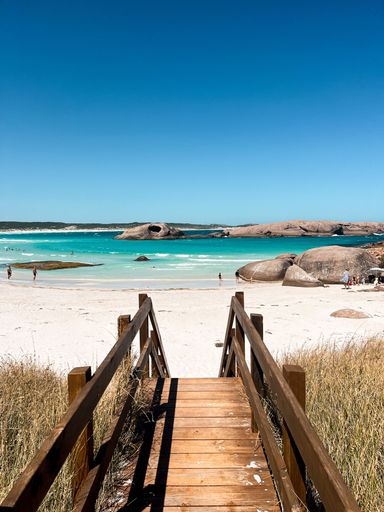 A beautiful landscape of a sandy beach from wooden stairs on a sunny morning