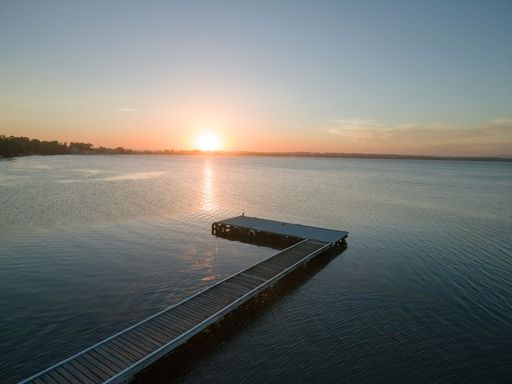 An aerial view of a wooden dock on Toukley lake at sunset in Australia