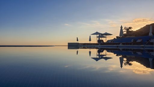 A beautiful shot of a clear swimming pool under the cloudy skies during the sunset
