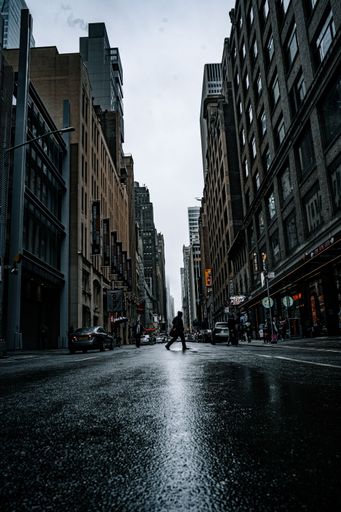 A shot of a busy street in New York on a rainy day, featuring a man passing the street