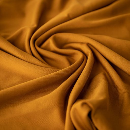 A brown shiny thick fabric photographed with wavy pattern