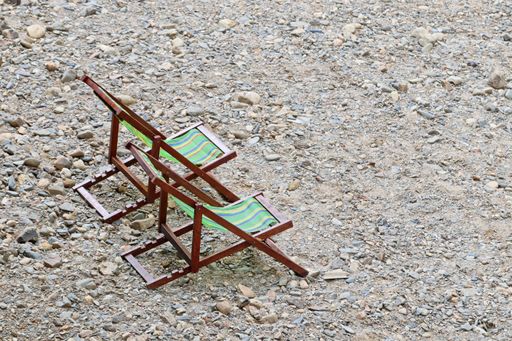 A high angle shot of comfortable wooden chairs at the beach