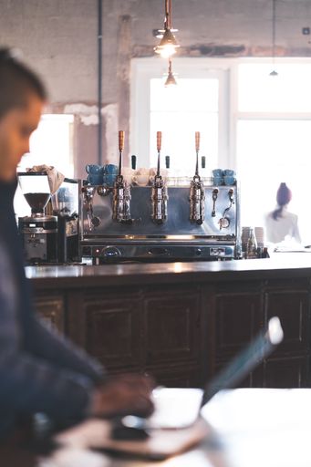 A vertical closeup shot of a large coffee machine in a coffee shop