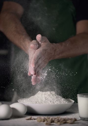 A vertical shot of a cook  cleaning his hands from flour