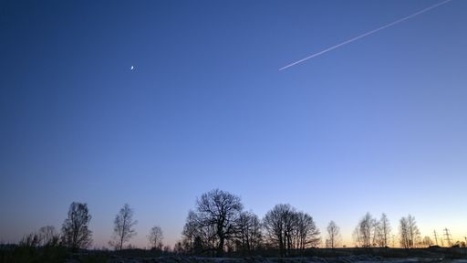 Jet in the sky with moon, beautiful sunset