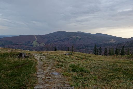 A beautiful landscape in mountains with pathway under blue cloudy sky