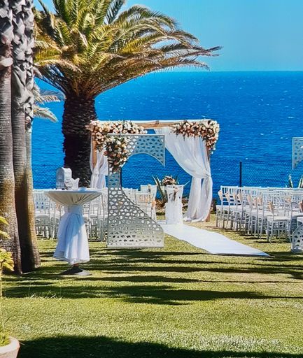 A vertical shot of a beautifully decorated alter for a wedding ceremony near palm trees on a beach