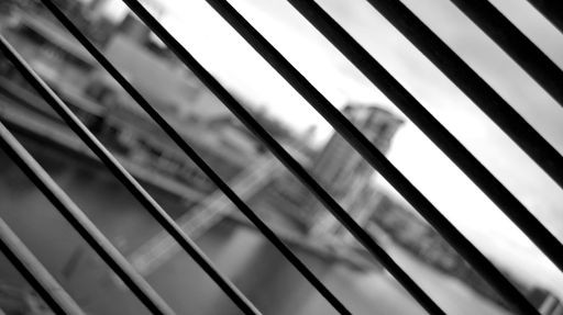 A monochrome shot of the blurred cityscape captured through the blinds