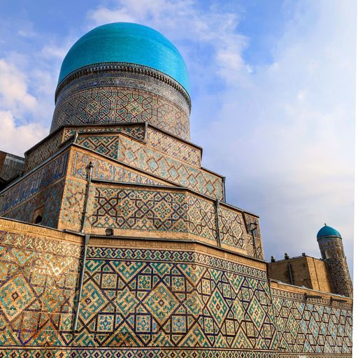 A vibrant tiled roof of an iconic mosque located in a bustling cityscape
