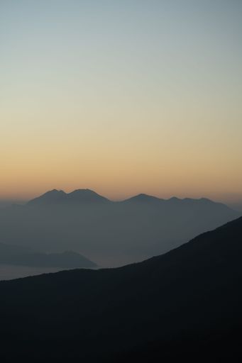 A vertical shot of mountain silhouettes during a sunset
