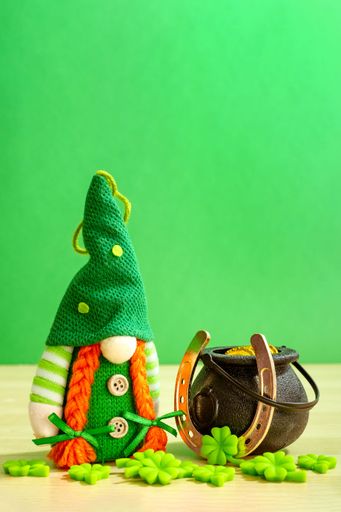 A bearded Scandinavian gnome with a green hat and clover leaves at St Patrick's day