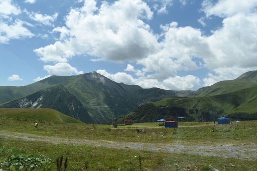 An image of green mountains under the cloudy sky.