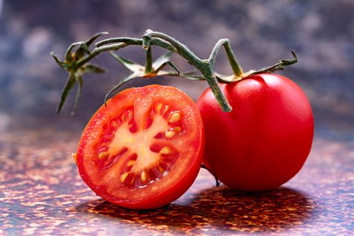 A ripe red tomato on a flat surface