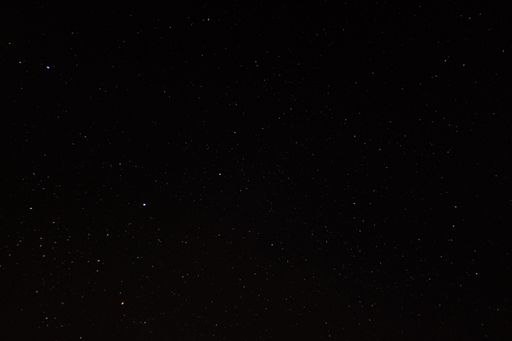 An image of a night skyline featuring a dark blue sky with stars twinkling in the background