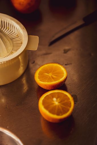 A vertical closeup shot of a lemon cut in two halves on a wooden table in the kitchen