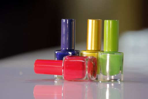 Bottles of colorful nail polish on a white table, Different colored nail polish