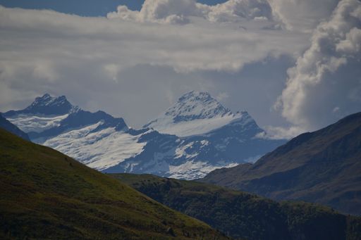 The big Rob Roy Glacier surrounded by the mountains under the cloudy sky in Southern Lakes, New Zealand