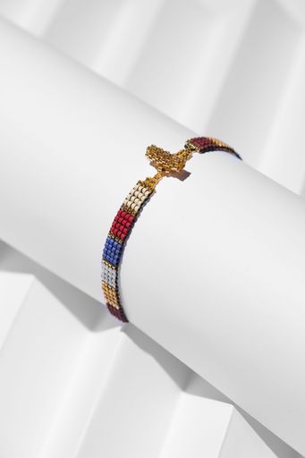 A vertical closeup shot of a handmade beaded bracelet on a white stand