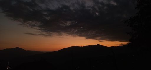 A panoramic shot of a bright sunset sky over beautiful mountains