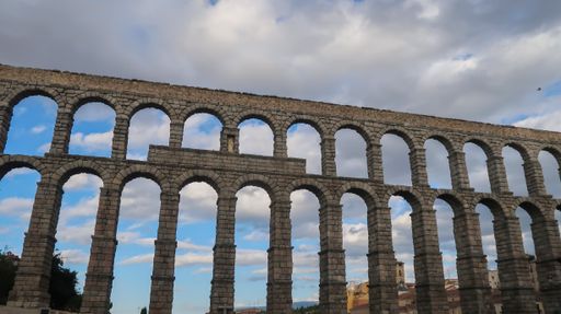 The Roman aqueduct in Segovia under cloudy sky
