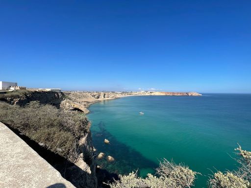 A high angle shot of a beautiful sea surrounded by white rock walls on a sunny day in The Algarve