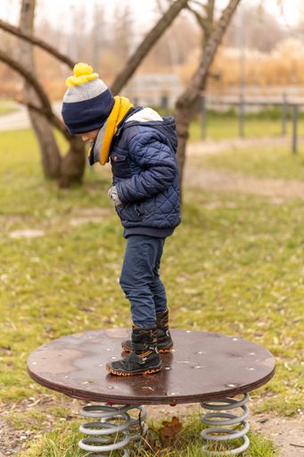 Young boy standing on a platform at a playground in the Rataje park.