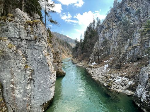 A beautiful scenery of a river between mountains under blue cloudy sky