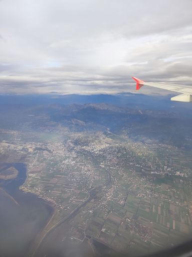 A vertical shot of the window view from an aircraft flying over an island