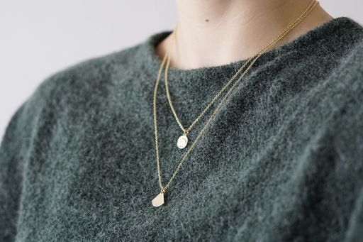 A female wearing a luxury layered necklace, closeup