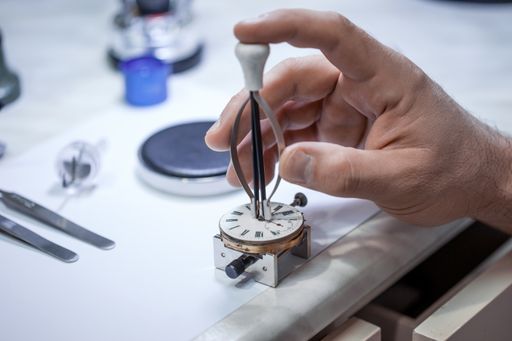 A closeup shot of a craftsman fixing gears on a clock