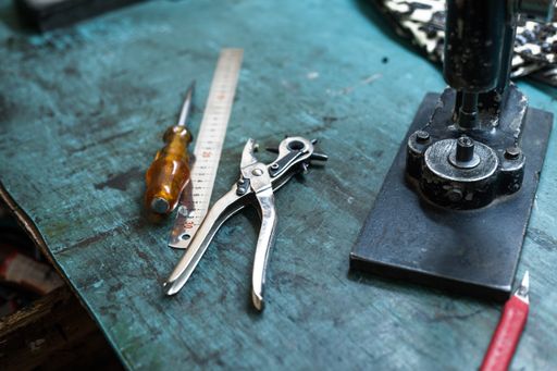 A closeup shot of leather tools on a craftsman table
