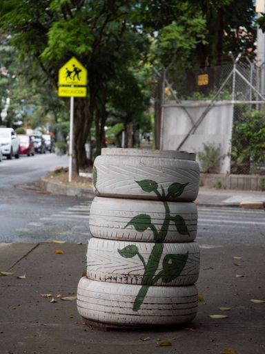 Recycled, Painted White and Green Tires Turned into a Street Trash Can