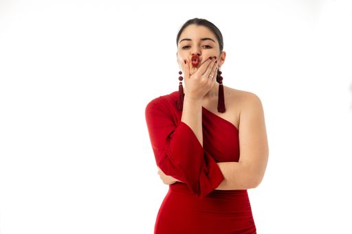 A happy attractive female in red dress posing on white background