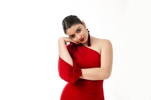 A peaceful beautiful female in red dress posing on white background