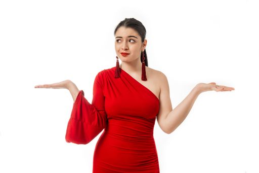A questioned attractive female in red dress posing on white background