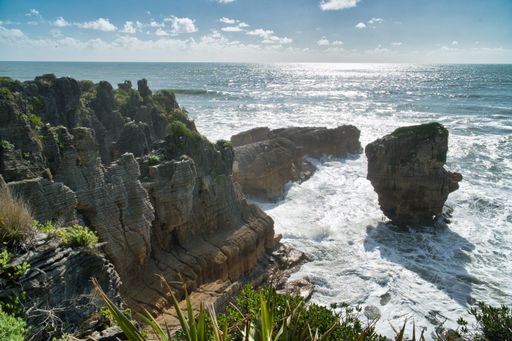 A beautiful landscape featuring large waves crashing against a rocky shoreline near the Pancake Rocks