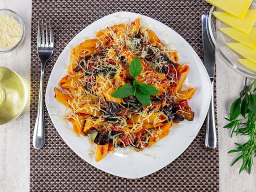 A top view of a plate of delicious gourmet pasta with cheese and mushrooms