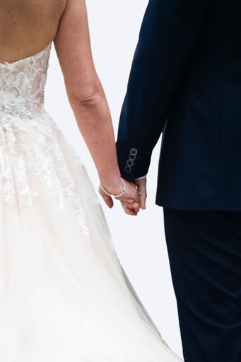 A happy newlywed couple join hands in a symbol of love and commitment as they celebrate their special day