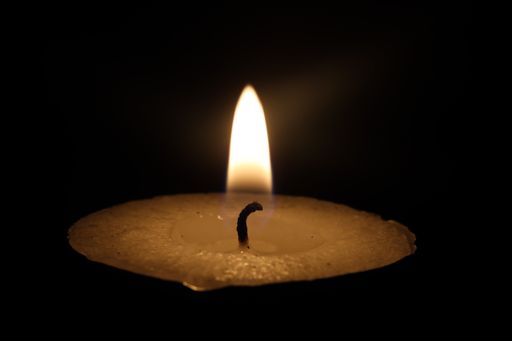 A closeup of a candle lit in a dark room