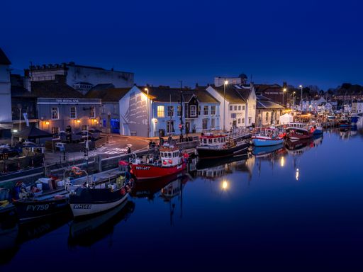 an Aerial shot of the Weymouth harbor at blue hour at night