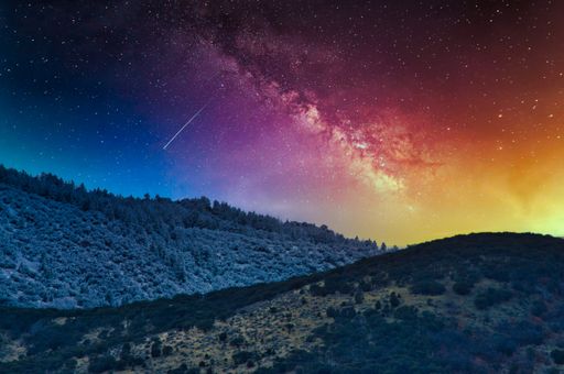 A mesmerizing starry sky over the forested mountains