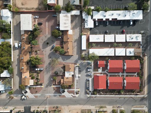 An aerial top view of a residential area with houses and parked cars