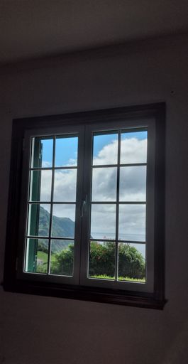 A vertical shot of a multi panel glazed window with a beautiful view