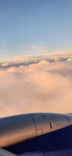 A vertical shot of an airplane in a beautiful cloudscape