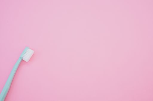 A top view of a new toothbrush isolated on a pink background