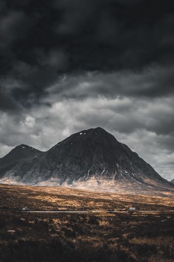 A vertical shot of a mesmerizing landscape with mountains under a stormy sky